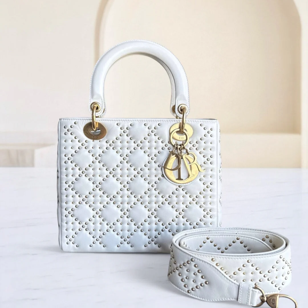 White handbag with gold accents on a light background