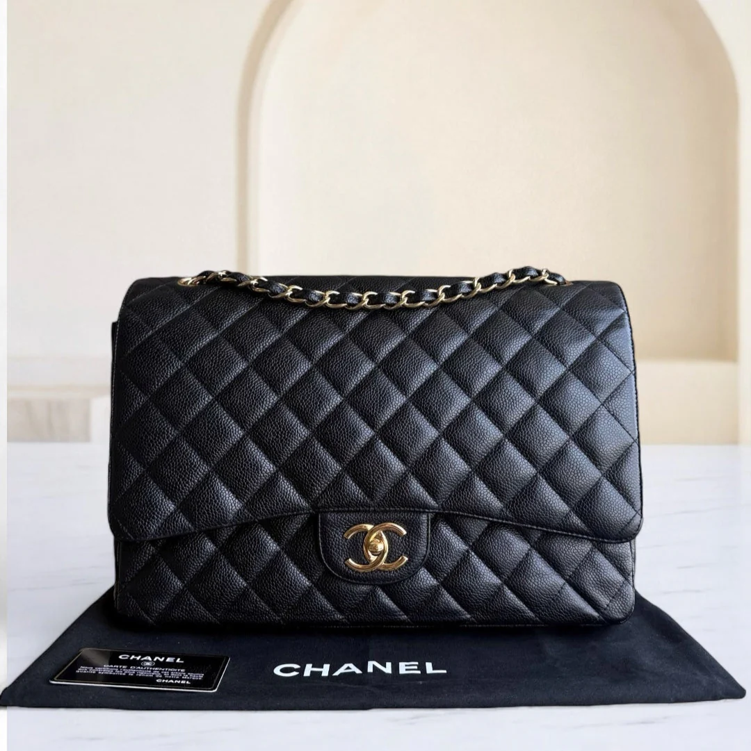 Black quilted Chanel handbag on a branded mat with a neutral background