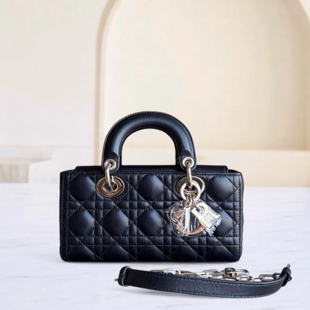 Black quilted handbag with gold hardware on a white surface