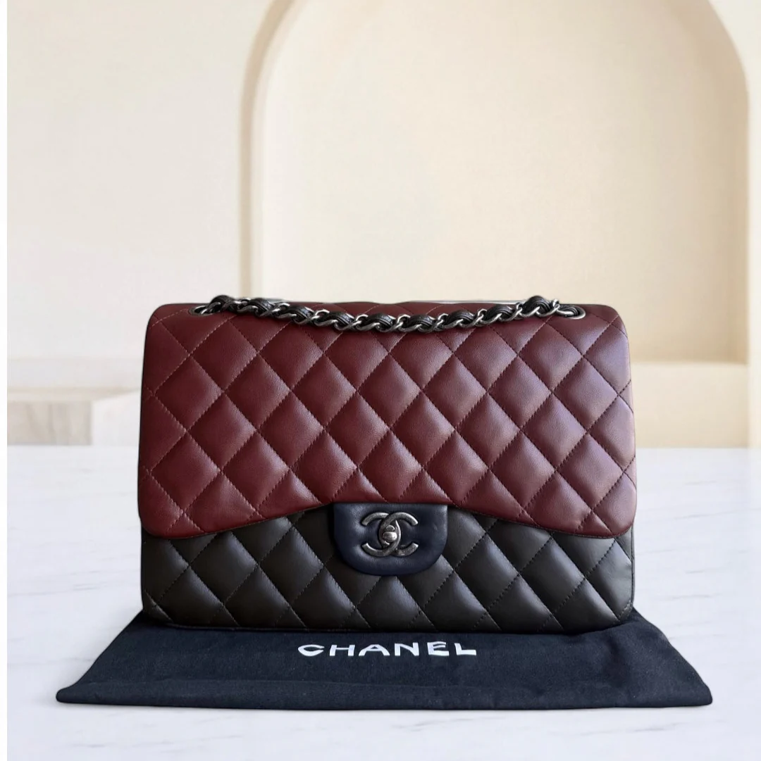 Chanel handbag with red and black quilted design on a white surface.
