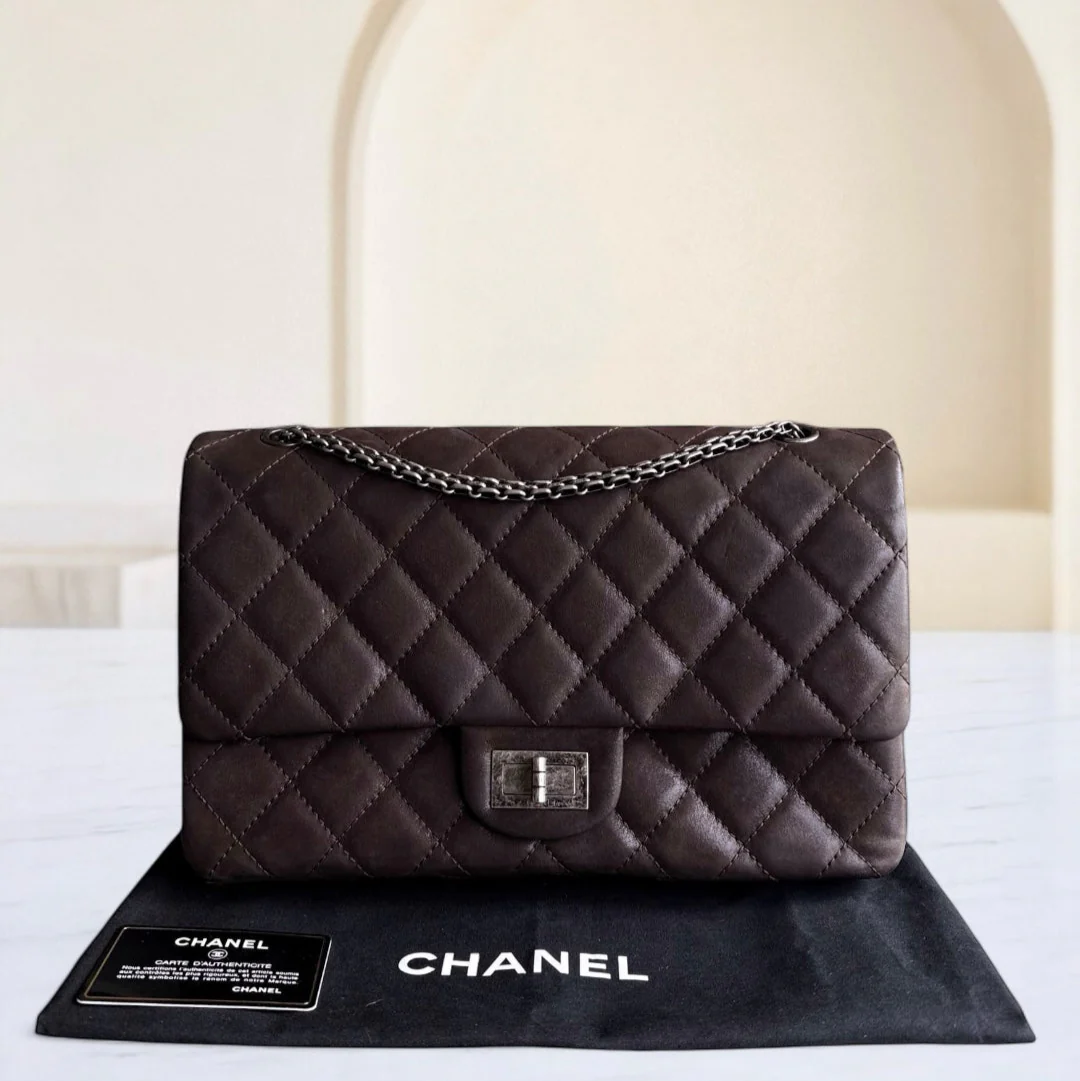 Chanel handbag on a black mat with a blurred background