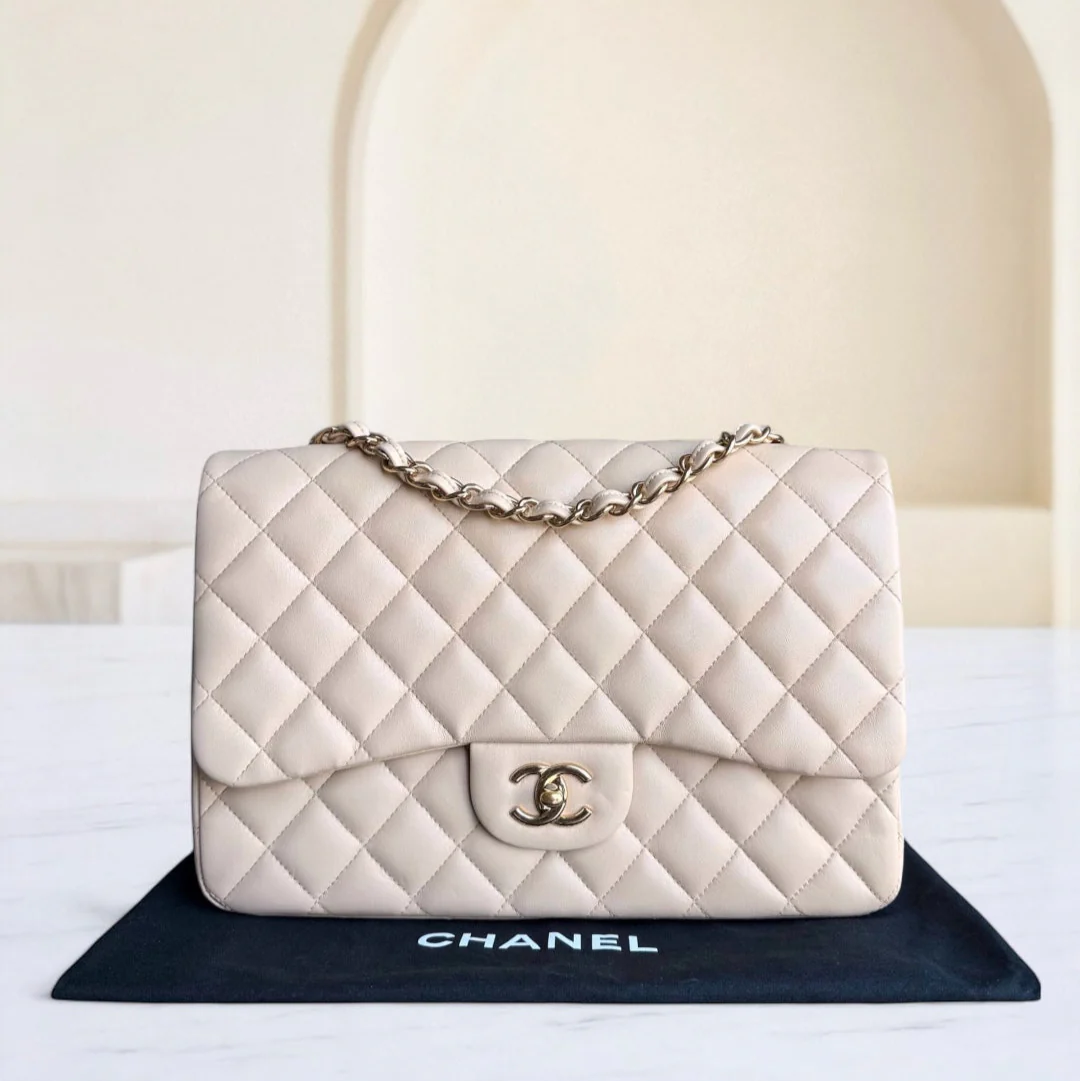 White quilted Chanel handbag on a black mat with a blurred background
