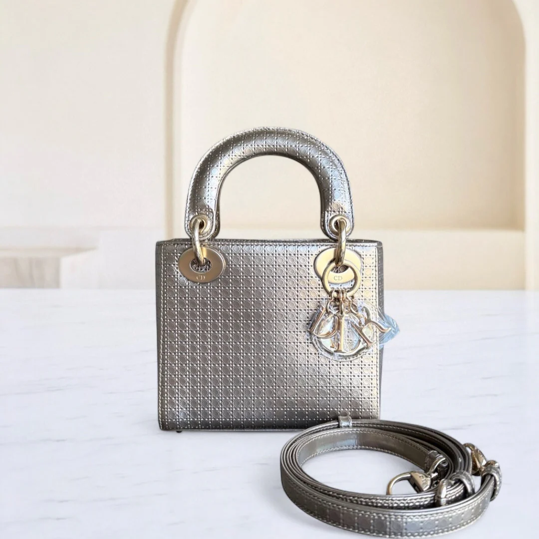 Silver handbag with matching strap on a white surface