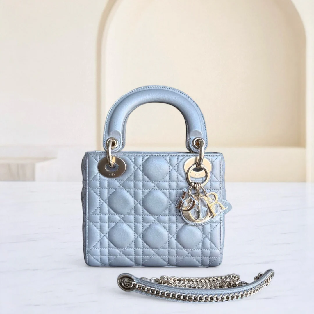 Light blue handbag with chain detail on a white surface