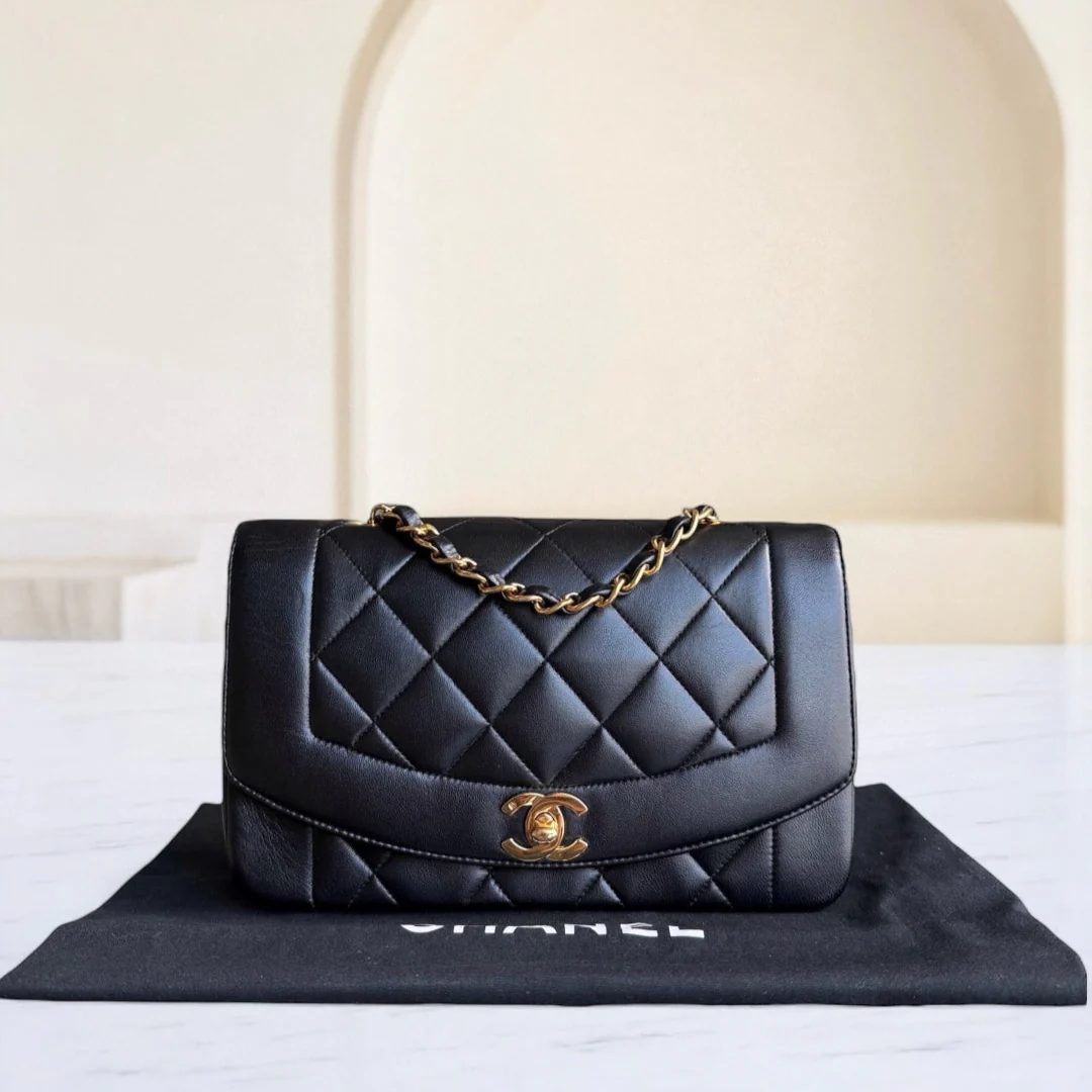 Black quilted handbag with gold chain on a Chanel branded mat