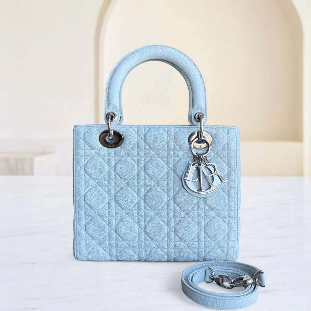 Light blue quilted handbag with Dior logo on a white surface