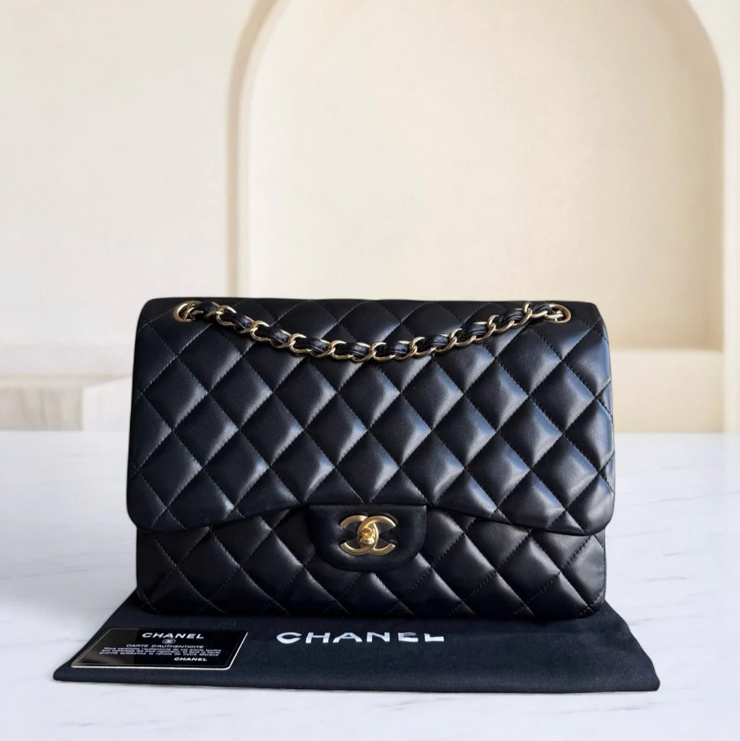 Black quilted Chanel handbag on a white surface with a neutral background