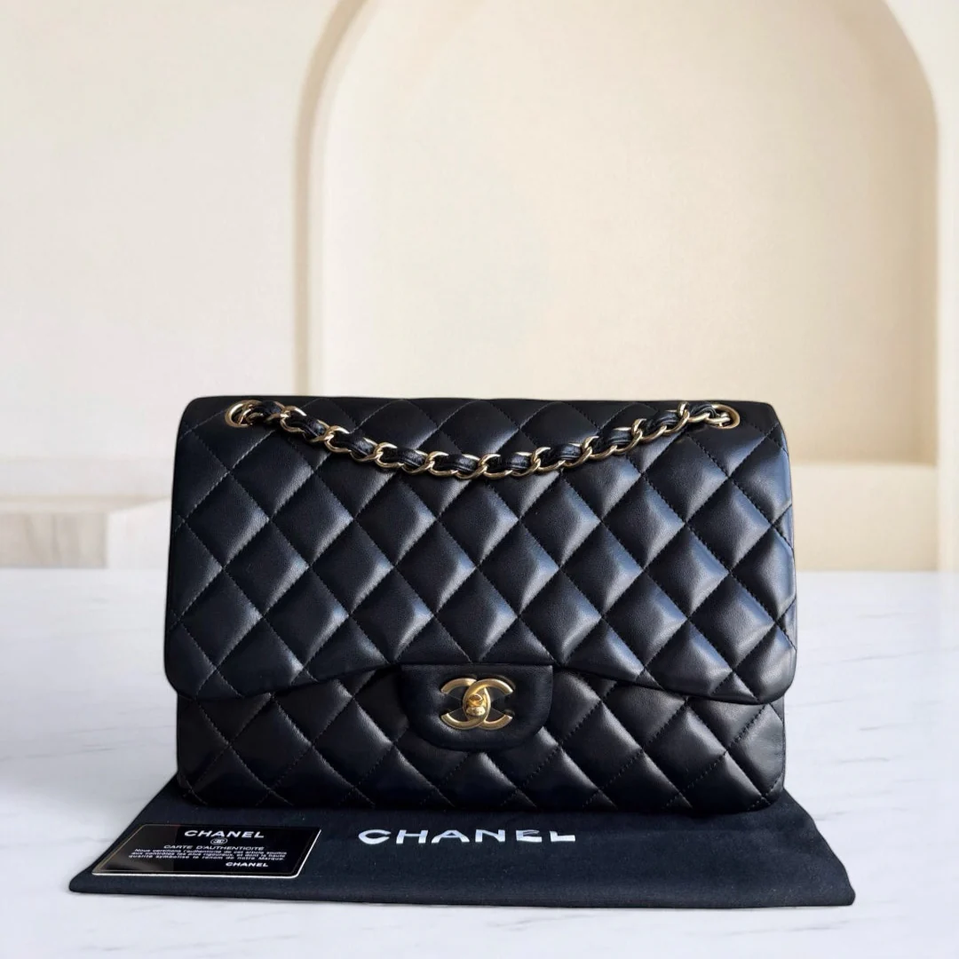 Black quilted Chanel handbag on a white surface with a neutral background