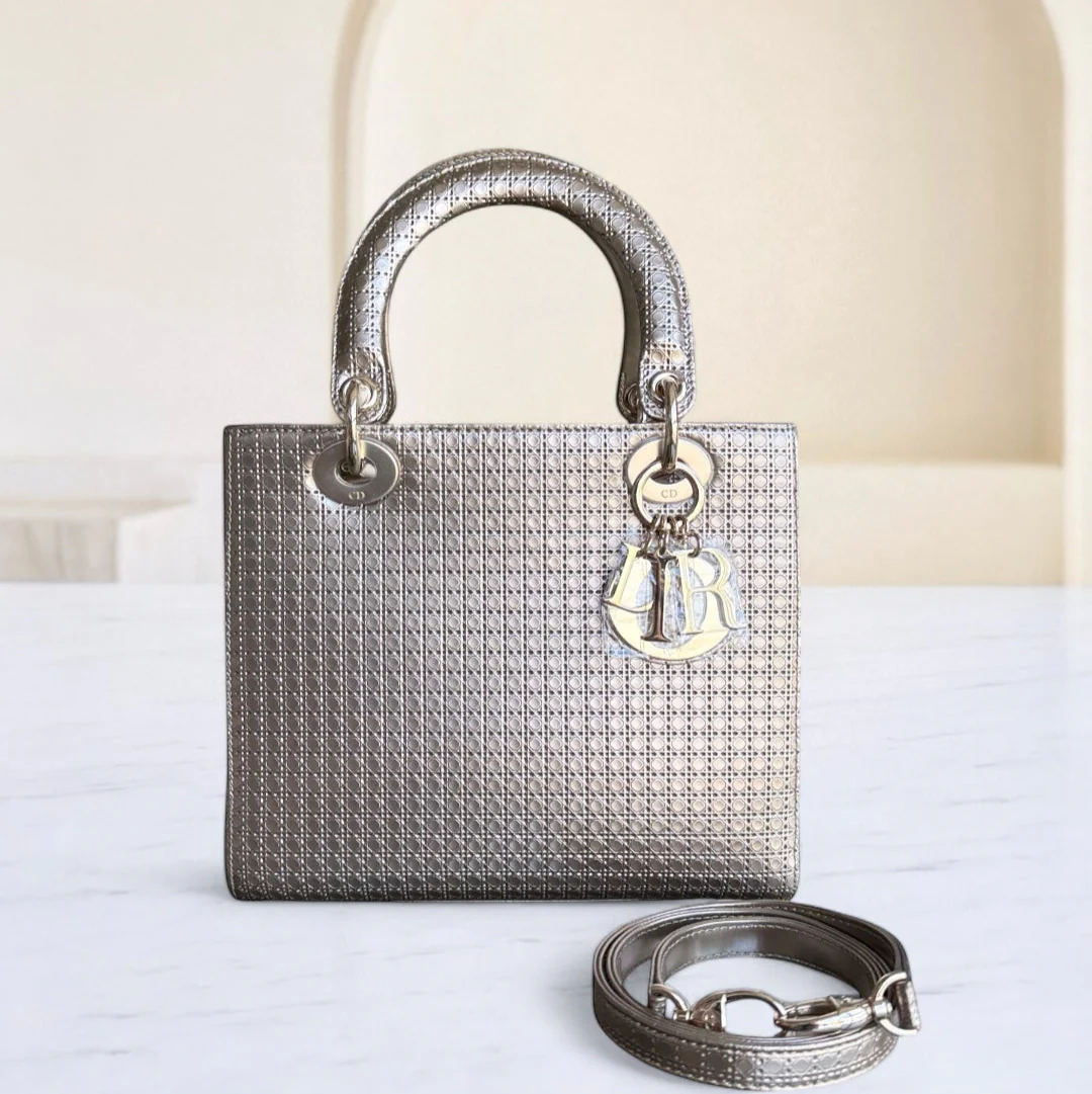 Silver handbag with a matching strap on a white surface