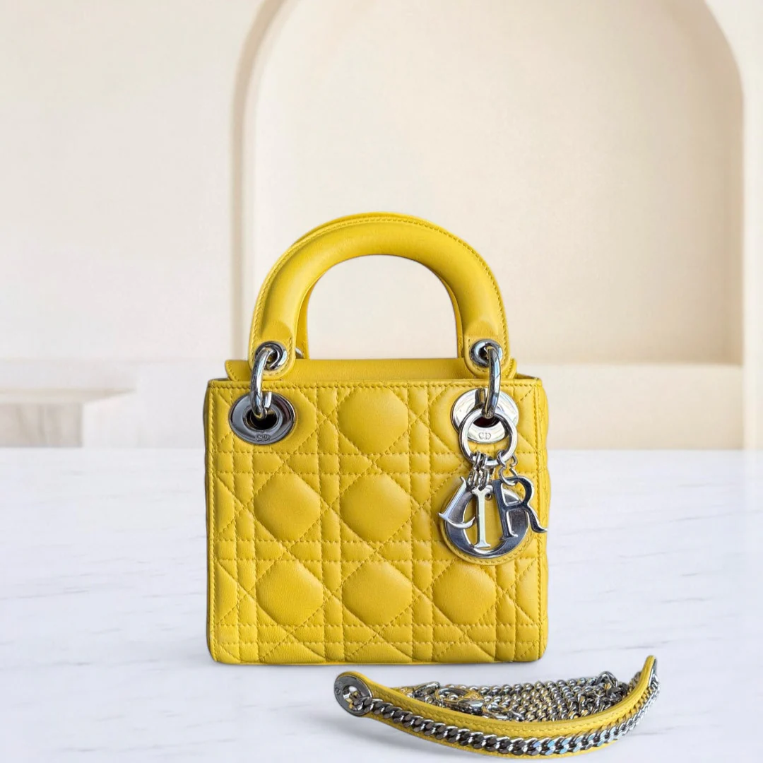 Yellow quilted handbag with chain detail on a white surface