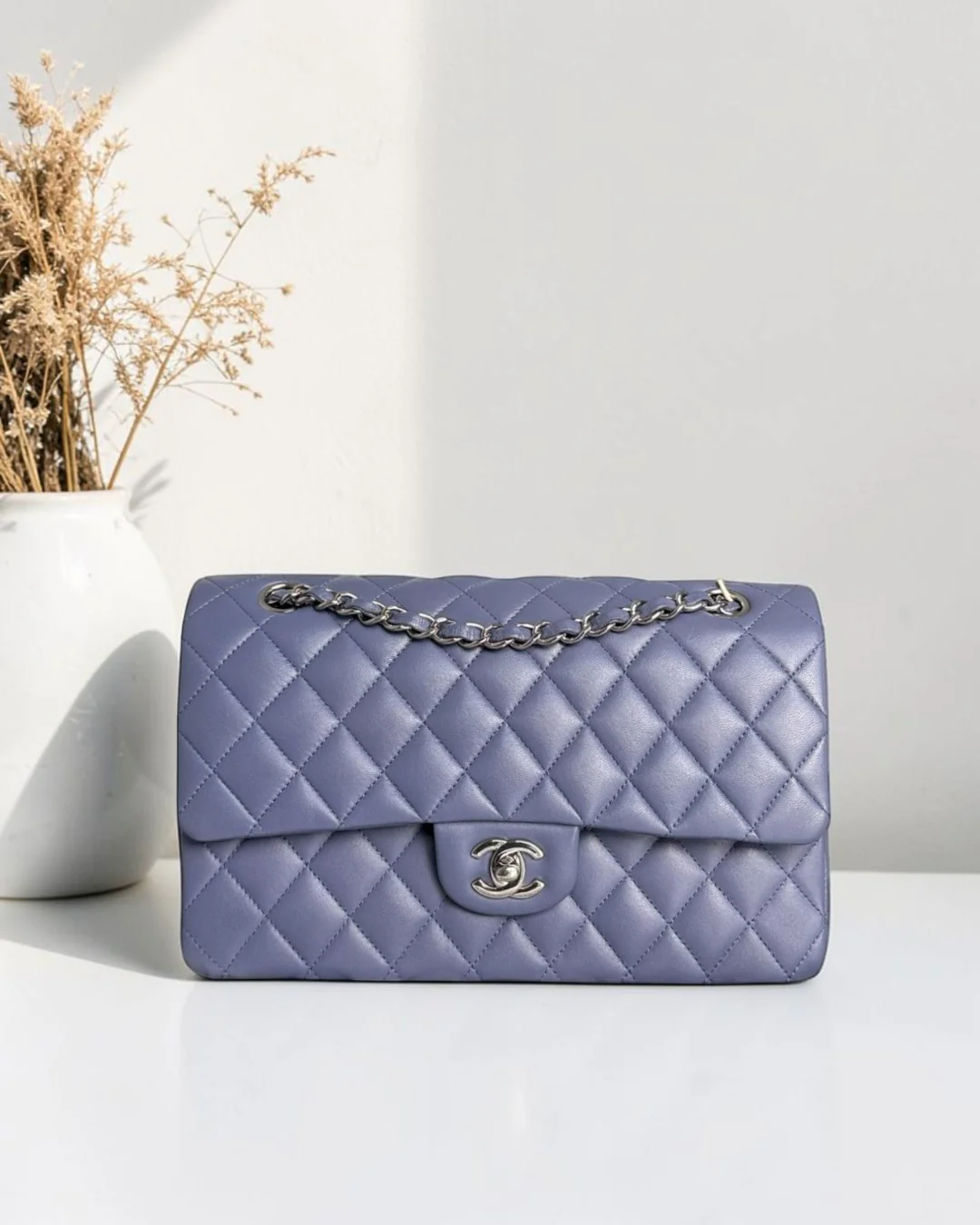 Best Luxury Designers Chanel Classic Flap Medium lavender quilted lambskin handbag with silver hardware and chain strap.