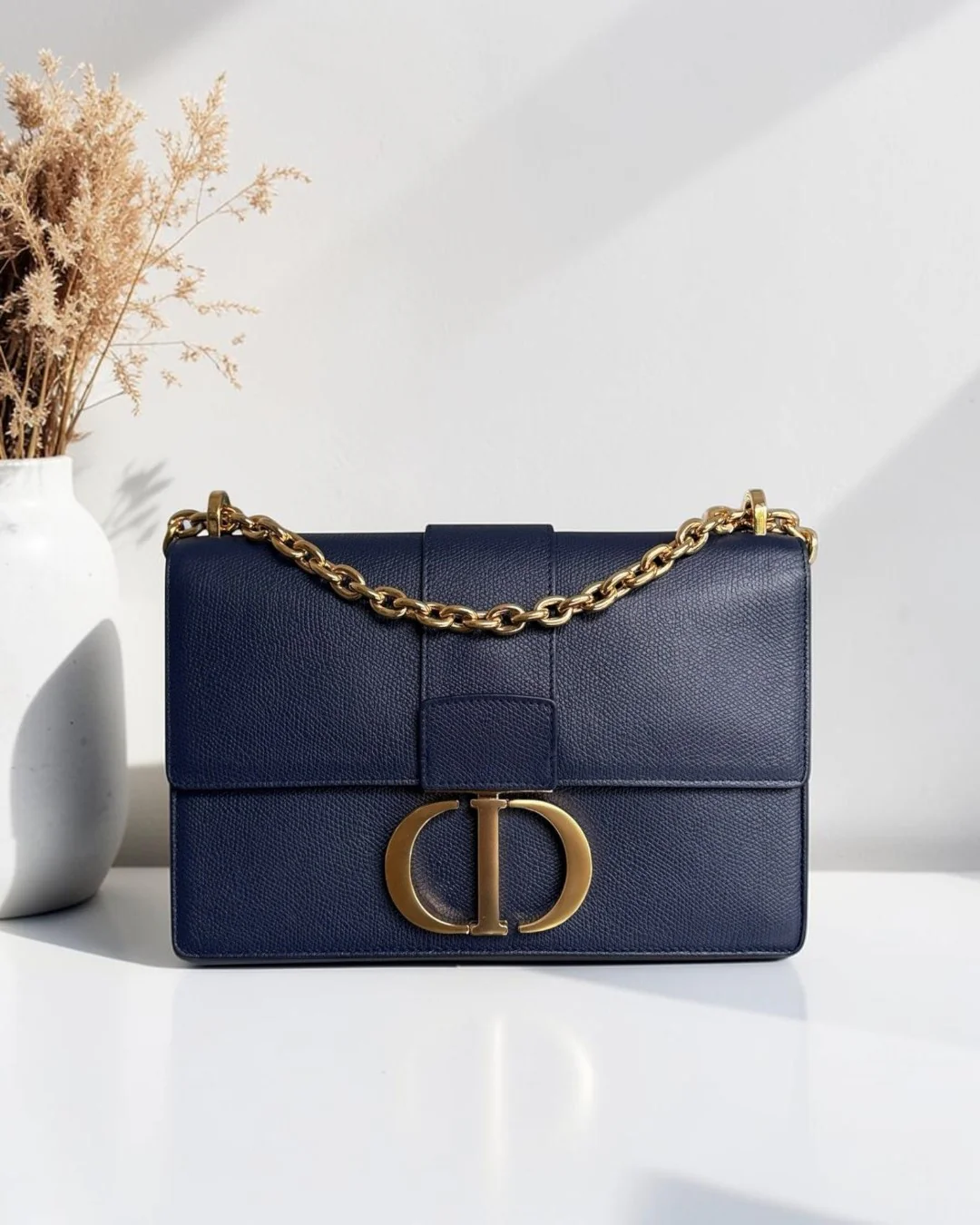 Best Luxury Designers dark blue caviar leather Dior 30 Montaigne medium bag with gold hardware and chain strap.