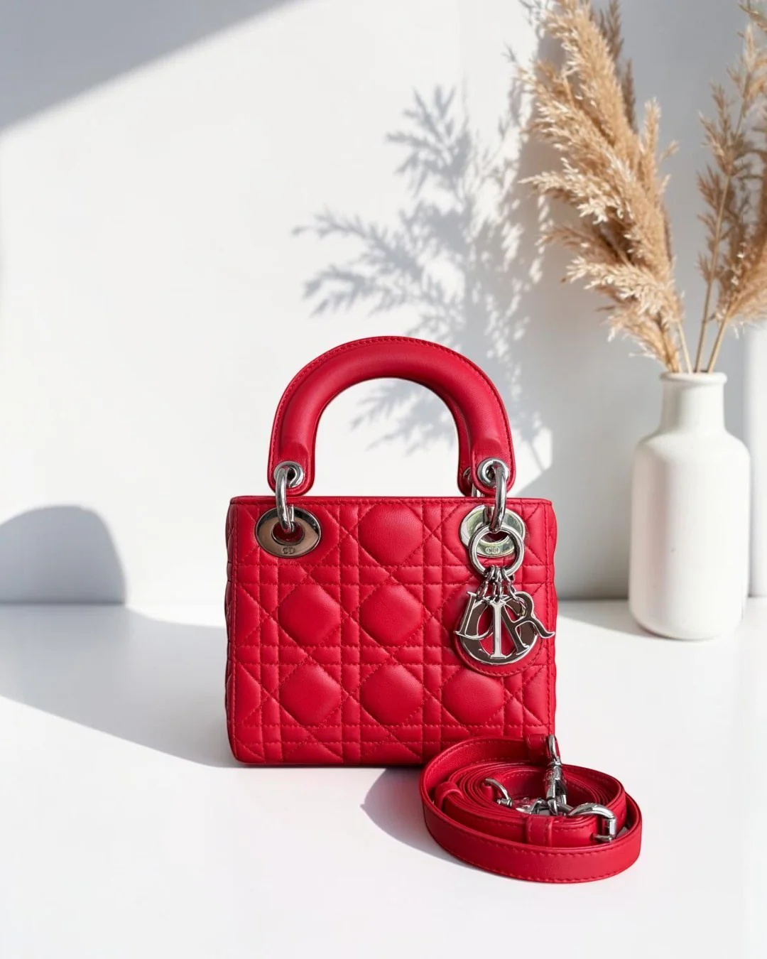 Best Luxury Designers red quilted leather mini handbag with top handle and detachable shoulder strap, silver hardware.
